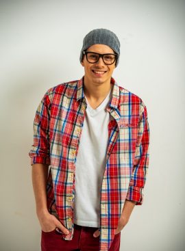 Young,Man,In,Glasses,And,Beanie,Smiling,Confidently,Against,Neutral Suks Minhas Male Fertility Expert